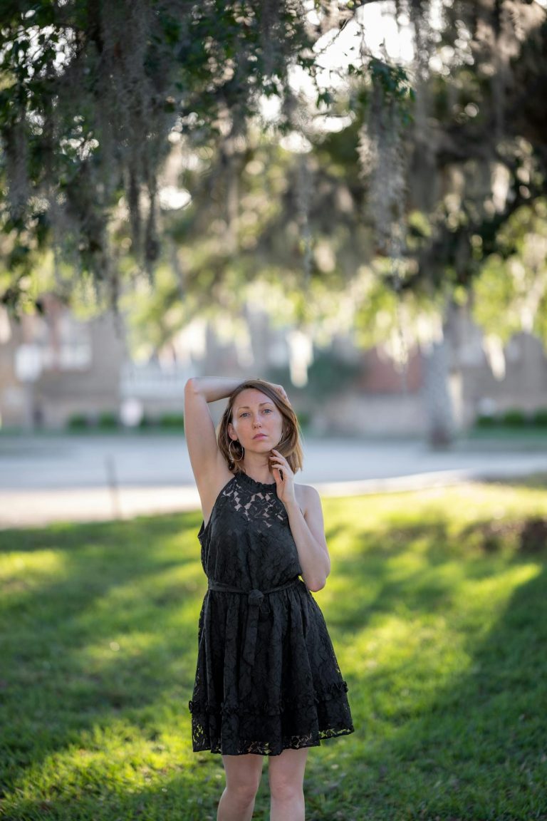 A beautiful young woman in a black dress posing for a photo
